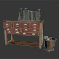 Wooden Drawer Cabinet With Metal Handles Old Books On Top And Metal Trash Bin Beside