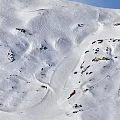 Skiing Scene On Snowy Mountain Slopes With Skiers And Clear Blue Sky
