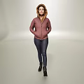 A woman in pink hooded jacket blue jeans and black boots standing against light background