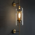 Modern Wall Lamp With Transparent Glass Shade And Golden Metal Warm Lighting On Dark Wall