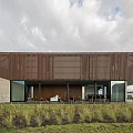 Modern Detached Villa Exterior With Corrugated Metal Cladding Large Glass Windows And Landscaped Grass Area