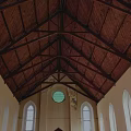 Traditional Church Building With Steeple Tower Brown Exterior Gray Roof Round Window And Arched Doorway