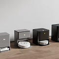 Different Colored Robotic Vacuum Cleaner Docks Arranged On Wooden Floor With White Wall