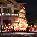 Giant Christmas Tree Balloon Decoration With Gift Boxes And Merry Christmas Sign Outside Building At Night