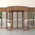 Modern Revolving Door With Bronze Frame Glass Panels And Potted Plants