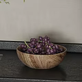 Fresh Purple Grapes in a Wooden Bowl on Dark Countertop with Light Background Wall