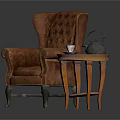 Brown Tufted Armchair With Wooden Legs And Small Round Table Featuring Teapot Teacup