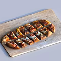 Delicious Pizza Slices with Various Toppings on a Wooden Cutting Board