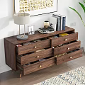 Wooden Dresser with Golden Handles Featuring Lamp Books and Green Plant on Top