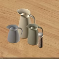 Silver Light Green White Milk Jugs Water Pitcher and Wooden Pepper Grinder on Wooden Table