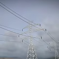 Road Facilities With Tall Transmission Towers Overhead Wires And Cloudy Sky