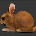 Small Orange Rabbit Figurine With Big Ears Black Eyes And Shiny Surface On Dark Background