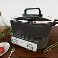 Modern Electric Kitchen Cooker With Olive Oil Bottle Fresh Tomato And Asparagus On Wooden Table