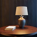 Stylish Table Lamp On Round Wooden Table With Two Books Against Dark Wooden Wall Background