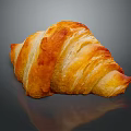 Golden Flaky Croissant On Dark Surface With Shiny Reflection
