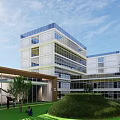 Modern Multi Story Industrial Factory Building With Glass Curtain Walls And Green Courtyard Lawn