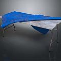 Patterned Blue Fabric Draped Over Metal Frame Table With Gray Top Surface