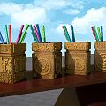 Four Golden Carved Decorative Pen Holders With Colored Pencils On Wooden Table
