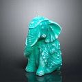 Turquoise Elephant Shaped Candle With Intricate Decorative Details On Black Background