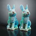 Two Turquoise Decorative Sitting Rabbit Statues on Dark Reflective Surface