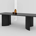 Modern Black Wooden Dining Table With Cylindrical Legs Topped With Brown Bottle And Small Cup