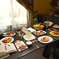 Sunlit Breakfast Spread On Table With Fresh Fruits Pastries Salad And Open Book