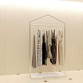 Various Stylish Clothes Hanging on Transparent Rack Against Beige Wall Background
