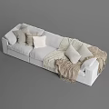 Cozy Light Colored Sectional Sofa with Soft Pillows and Fringed Woven Blankets in Living Room