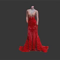 Mannequin Wearing Elegant Red Gradient Gown With Lace Embroidery And Flowing Train Against Dark Background