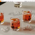 Wine Bottle and Three Glasses with Orange Drink Ice Cubes on Table 3d model
