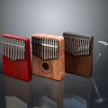 Three Different Colored Wooden Kalimba Musical Instruments With Decorative Patterns And Small Hammer