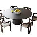 Modern Round Black Dining Table with Six Wooden Frame White Cushion Chairs and Fruit Bowl