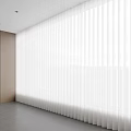 White Vertical Curtains In Bright Modern Room With Wooden Cabinets And Shelves