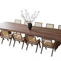 Long Wooden Dining Table with Eight Rattan Back Chairs and Black Decorative Vase