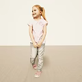 Little Girl with Pigtail Wearing Pink T-shirt Gray Pants and Pink Shoes on Light Background