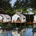 Lakeside Glamping Site with Overwater Platforms White Tents and Wooded Surroundings