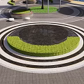 Water Fountain in Public Square with Circular Green Surrounding and Black White Patterned Pavement