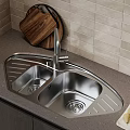 Stainless Steel Kitchen Sink With Faucet Wooden Cutting Board Paper Towel and Pears on Countertop