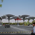Contemporary Entrance Gate With Solar Panel Canopies Red Signage And Moving Vehicles