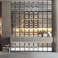 Stylish Glass Block Wall with Circular Holes and Lighted Interior Featuring Silver Console Table and Decor Items