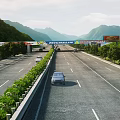 Highway Road Facilities Featuring Multiple Lanes Green Belts Trees Billboards And Scenic Mountain Views
