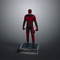 Red Superhero Statue Standing On Square Base With Red Costume And Daggers