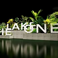 Floral Installation Featuring White 3D Letters Green Plants Yellow Flowers And Water Reflection