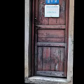 Vintage Old Wooden Door With Blue Sign And Weathered Frame