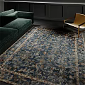 Blue Floral Pattern Square Rug In Living Room With Green Sofa And Chair