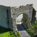 Ancient Stone Arch Ruins In Countryside With Green Grass And Pathway