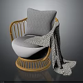 Cozy Rattan Chair with White Cushion Gray Geometric Pillow and Patterned Blanket