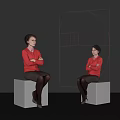Two Women Wearing Red Blouses Sitting On Gray Cubes With Red Geometric Design