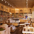 Spacious Mall Retail Store Interior Featuring Wooden Shelves Various Products And Shopping Customers