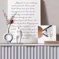 White Console Table with Vase Red Flowers Statue Photo Frame Books Against Light Wall